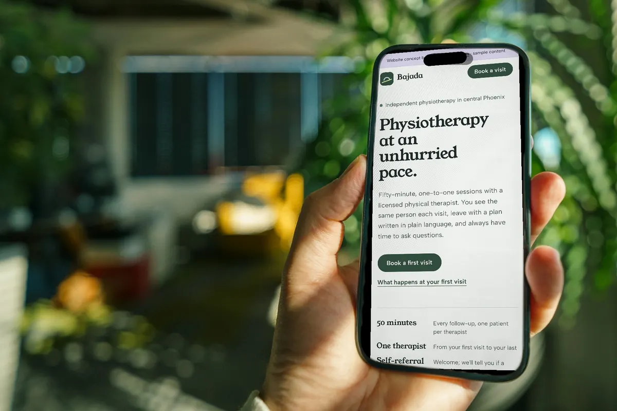 A physiotherapy clinic website concept on a phone held in someone&rsquo;s hand
