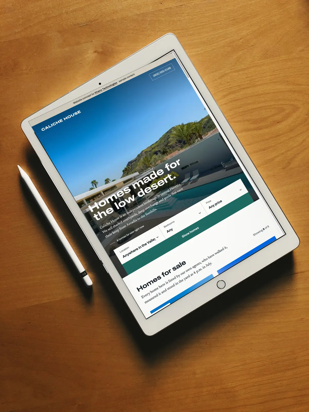 A real estate website concept open on an iPad on a wooden table, headline &ldquo;Homes made for the low desert.&rdquo;